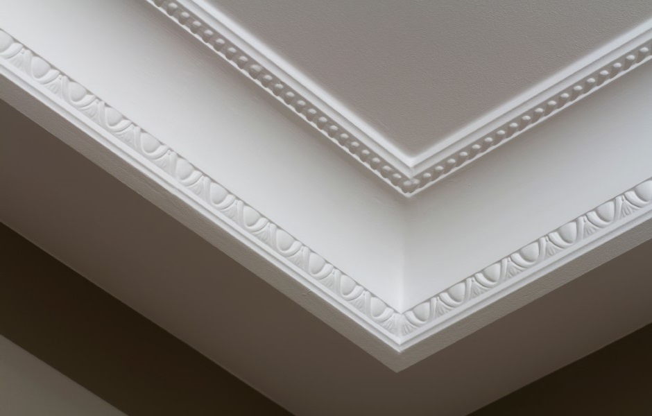 Image of ornamental white crown molding with decorative small, rounded details like beads or pearls.