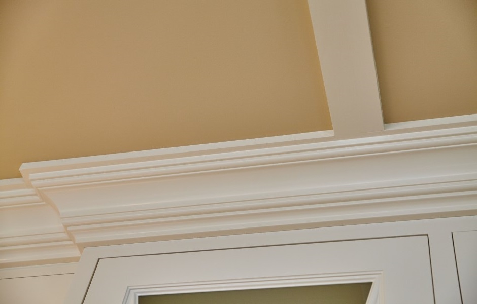 Image showcasing detailed colonial-style crown molding and door frame trim in a home interior.