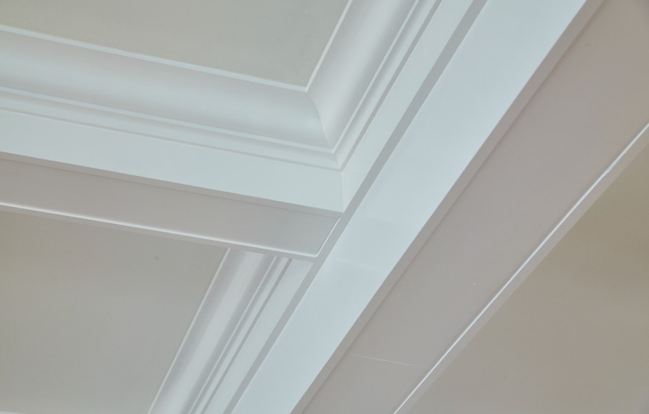 Image of a contemporary minimalist ceiling with geometric crown molding, showcasing a white ceiling and wall.