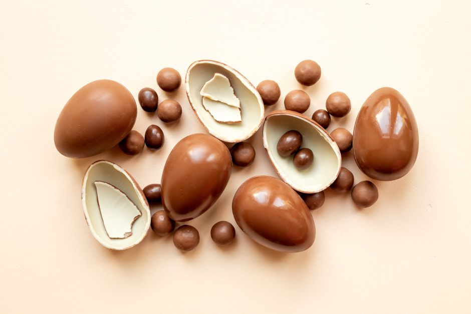 Several chocolate Easter eggs in various sizes, image background in light brown color