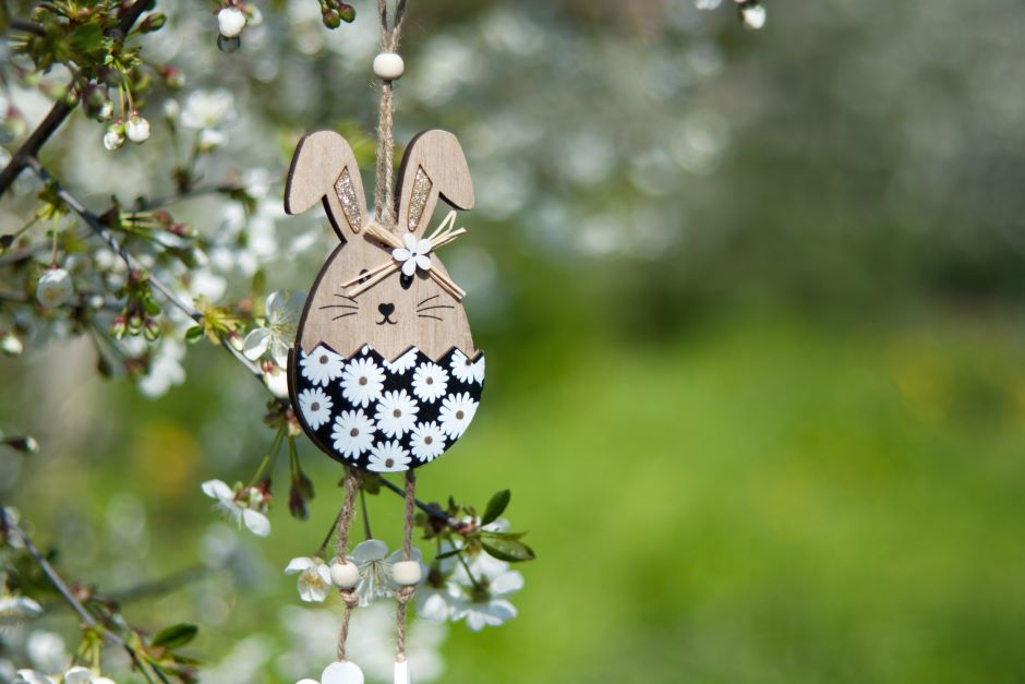 Easter decoration hanging on garden tree branch, egg-shaped bunny