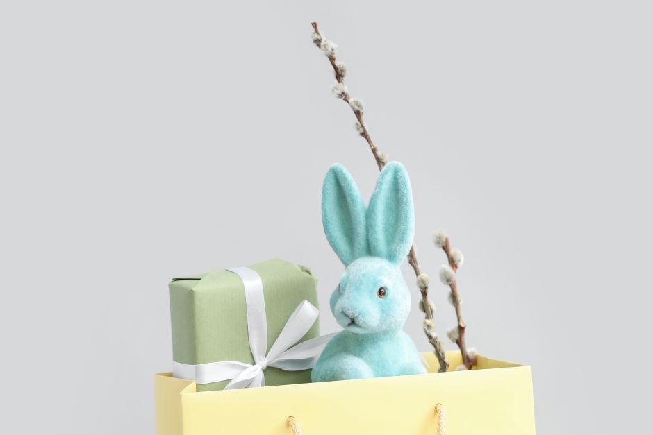 Gift bag with a plush bunny and a branch with small white flowers, image background in white color