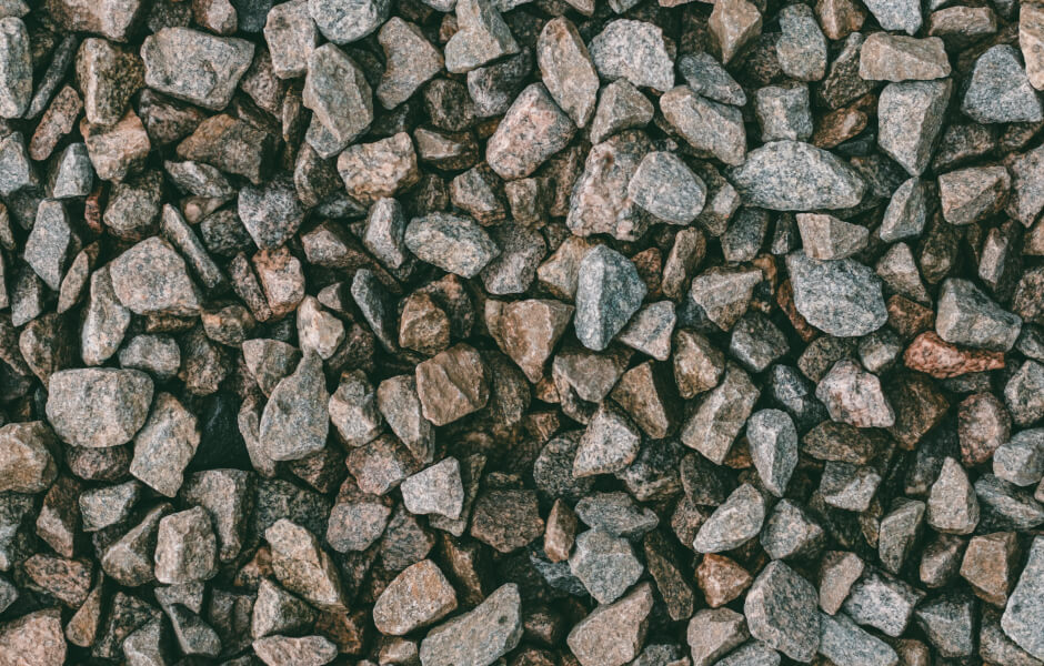 Image of various small crushed granite stones in different shapes, viewed from above.