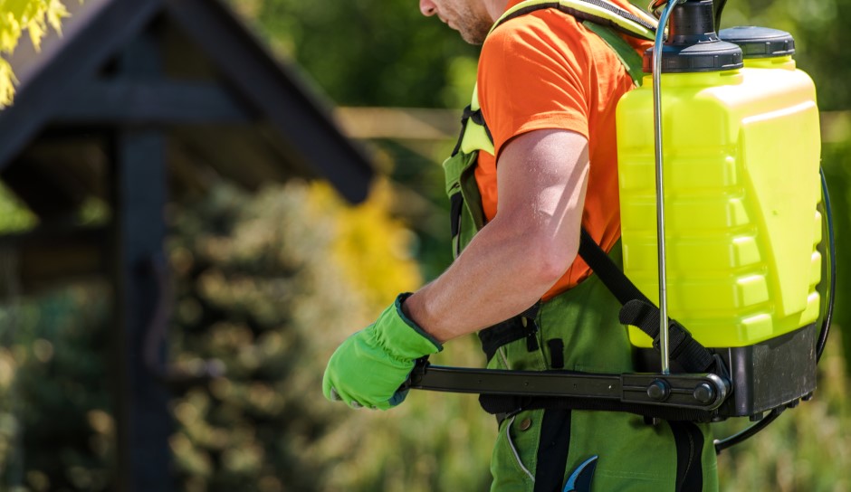 Gardener carrying a pump sprayer